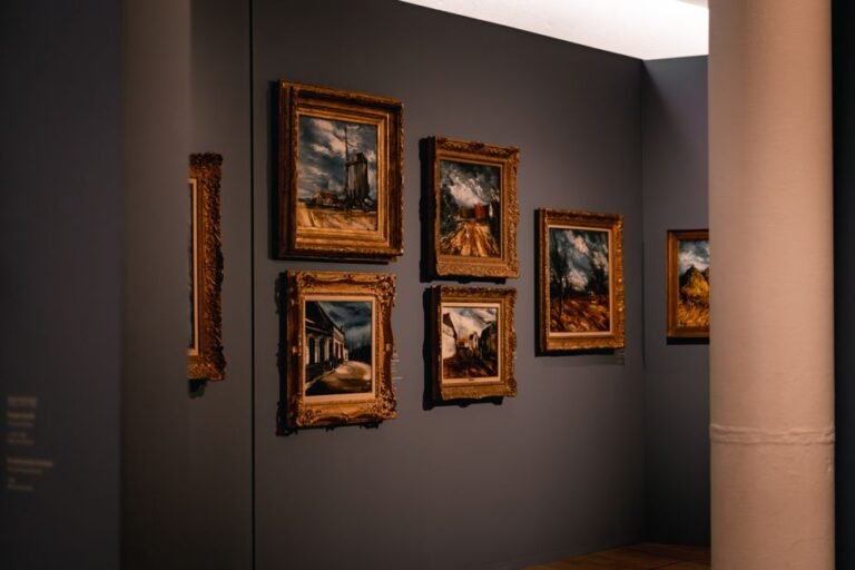 Galería de cuadros góticos con marcos dorados ornamentados en una pared oscura